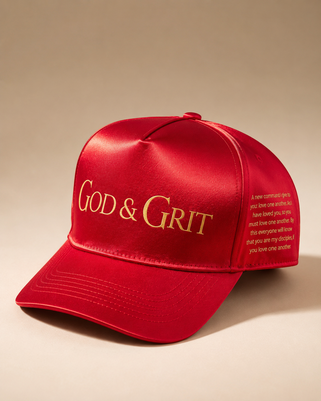 God & Grit red satin baseball cap with gold embroidered branding and scripture text on the side panel